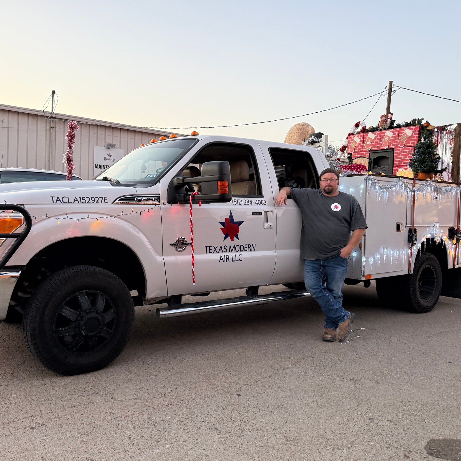 A modern gray residential air conditioner unit installed on a concrete slab next to a home in Tulsa, OK.
