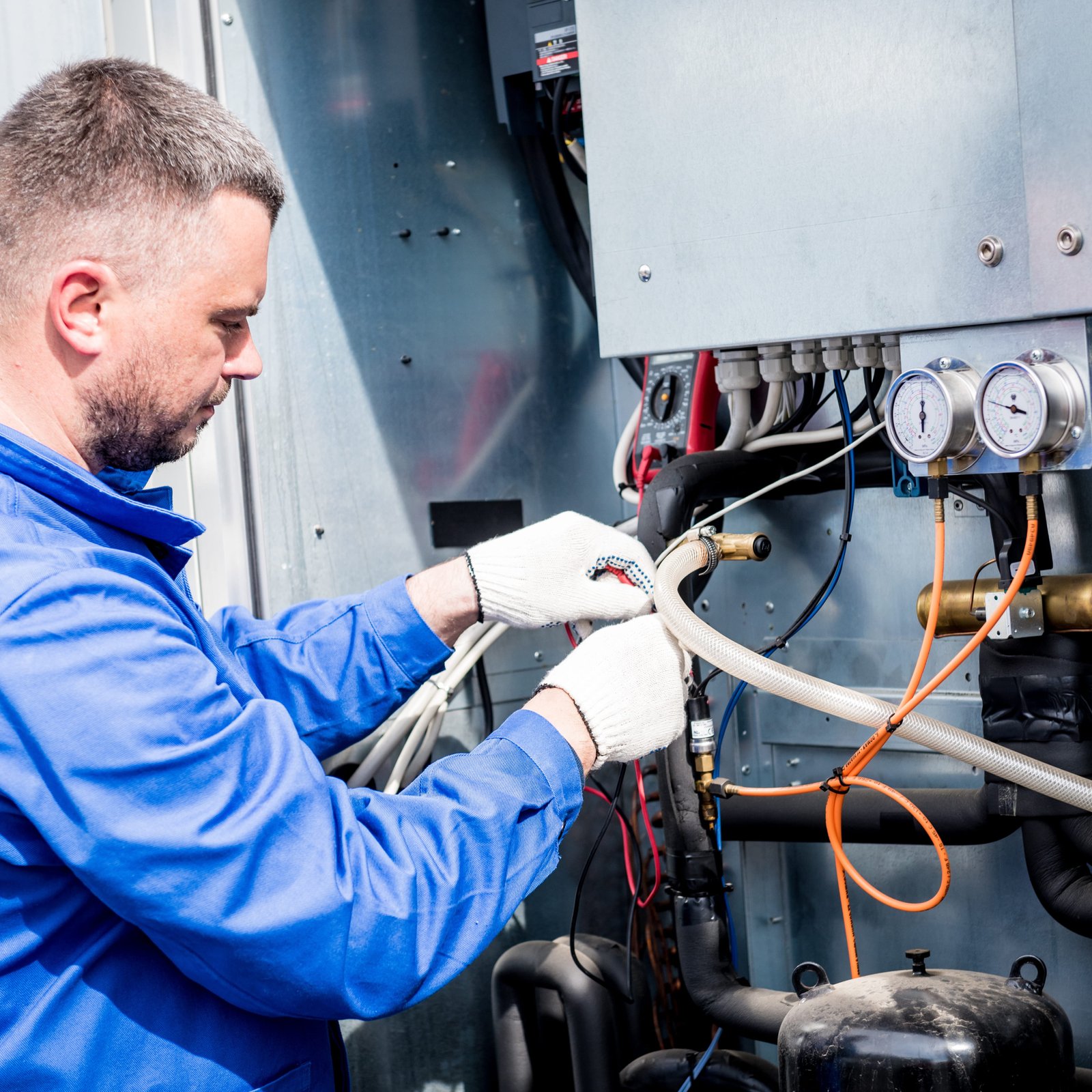 Air Dynamics of Tulsa technician diagnosing an HVAC issue during a service call.